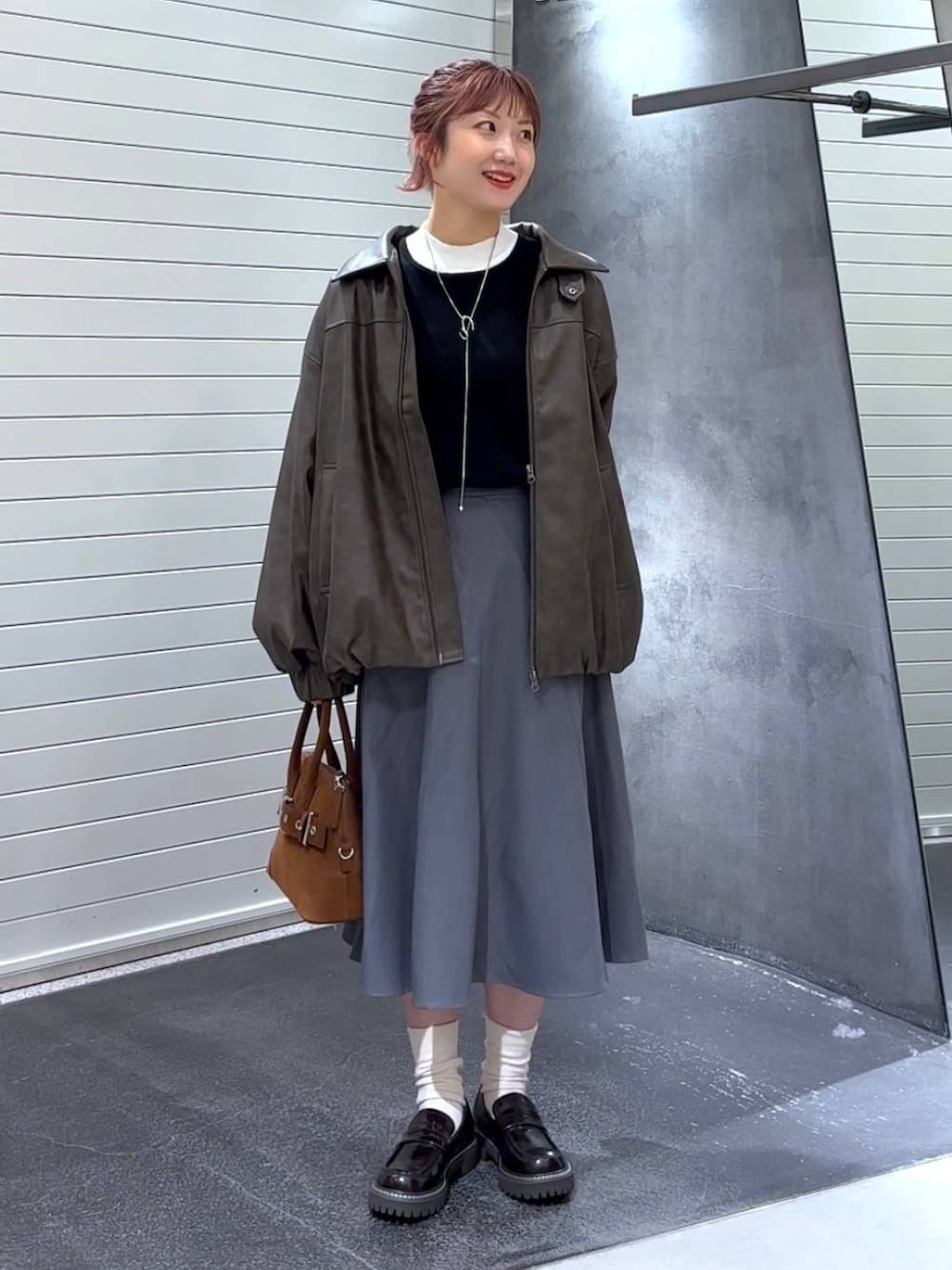 ブラウン系のブルゾン、ブラウン系のローファー、ブラウン系のボストンバッグを着用したレディースの秋コーディネートの2枚目の写真