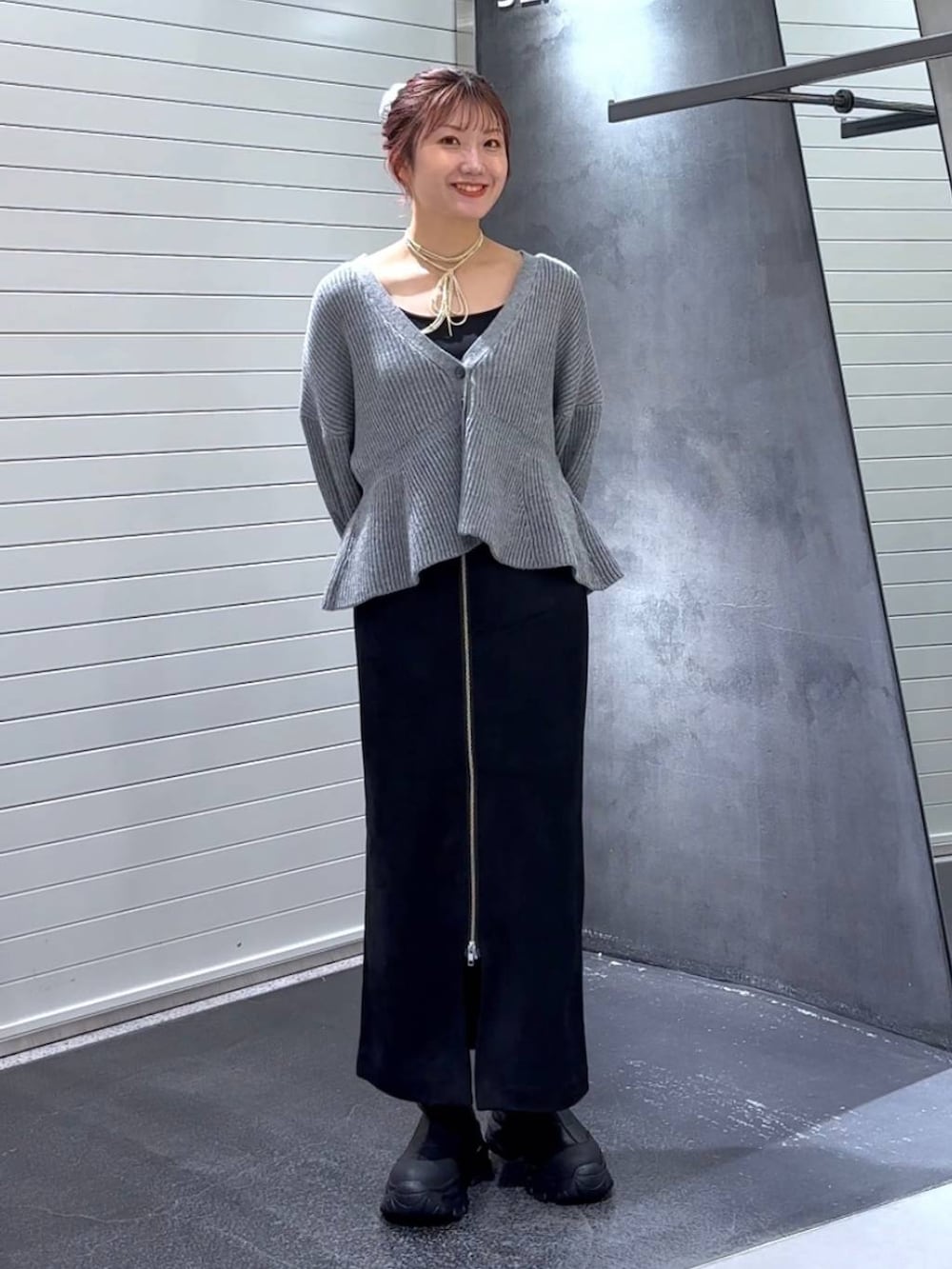 ブラック系のスカート、ブラック系のブーツ、グレー系のカーディガン/ボレロを着用したレディースの秋コーディネートの2枚目の写真