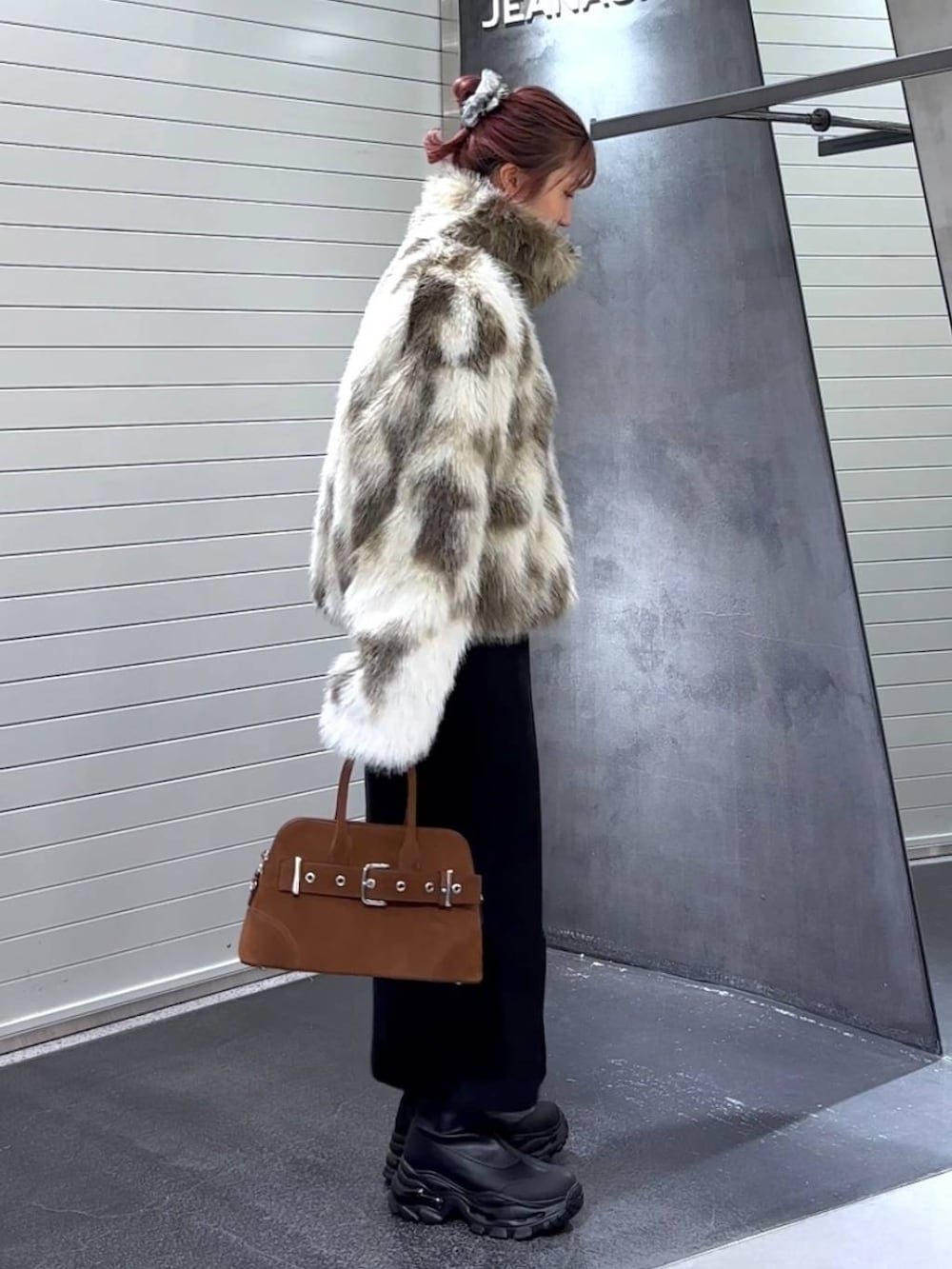 ブラック系のスカート、ホワイト系のブルゾン、ブラック系のブーツを着用したレディースの秋コーディネートの4枚目の写真