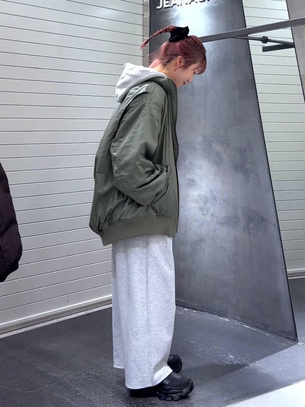 ブラック系のブーツ、グリーン系のブルゾン、グレー系のパーカーを着用したレディースの冬コーディネートの4枚目の写真