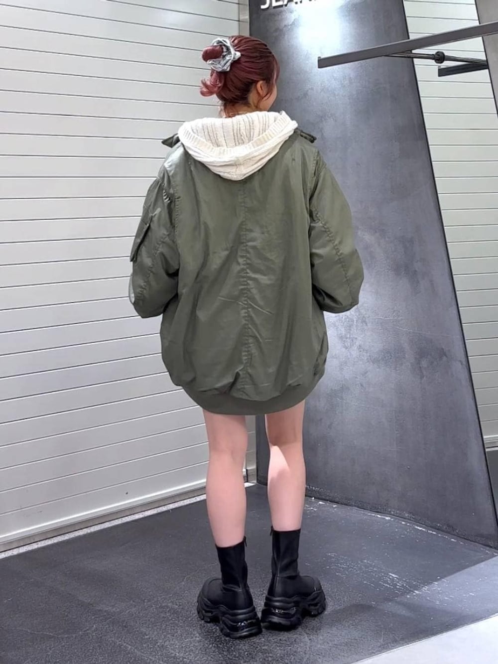 ブラック系のブーツ、グリーン系のブルゾン、ホワイト系のパーカーを着用したレディースの秋コーディネートの6枚目の写真