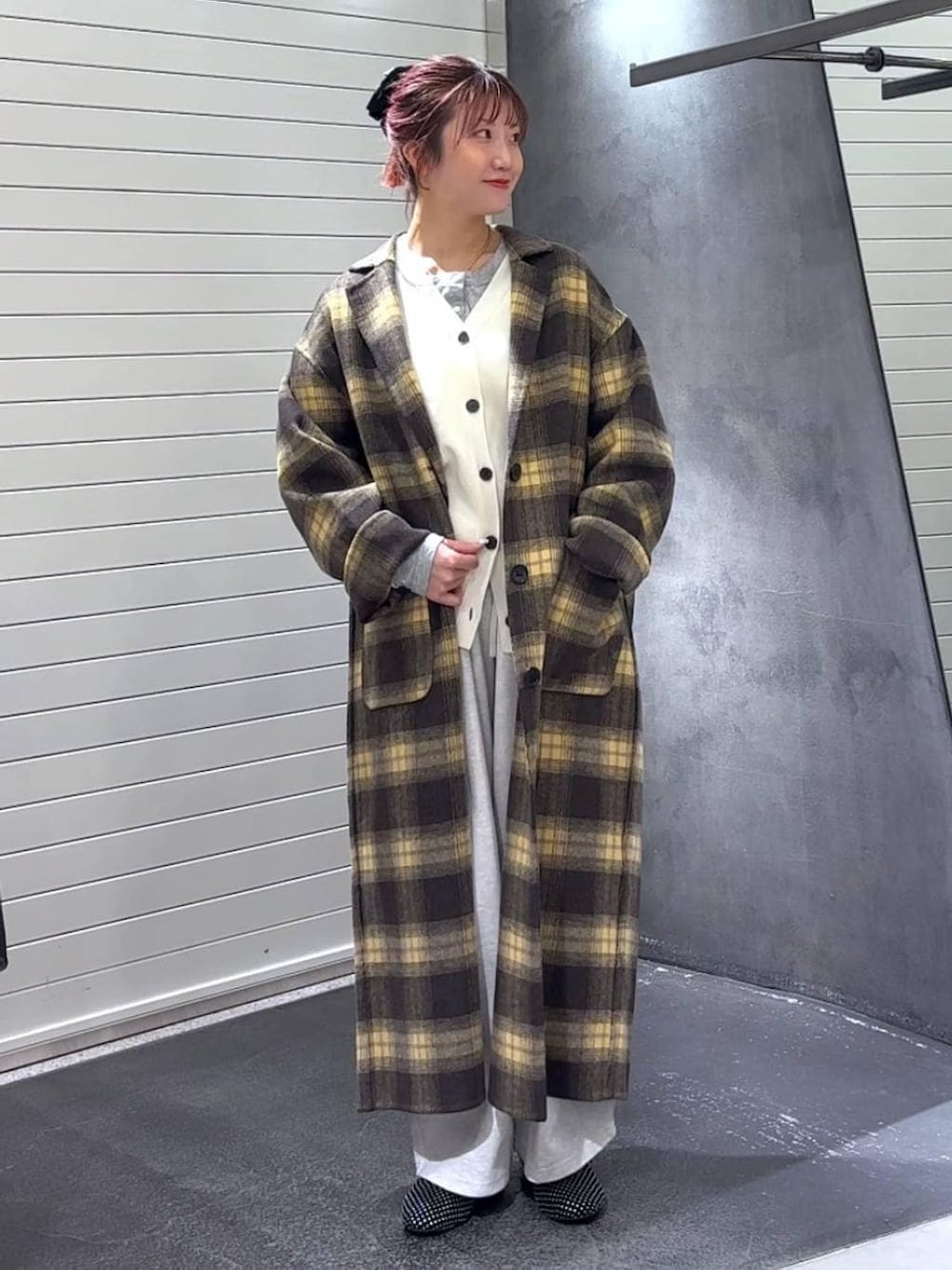 ブラウン系のチェスターコート、ブラック系のパンプス、グレー系のTシャツ/カットソーを着用したレディースの冬コーディネートの2枚目の写真