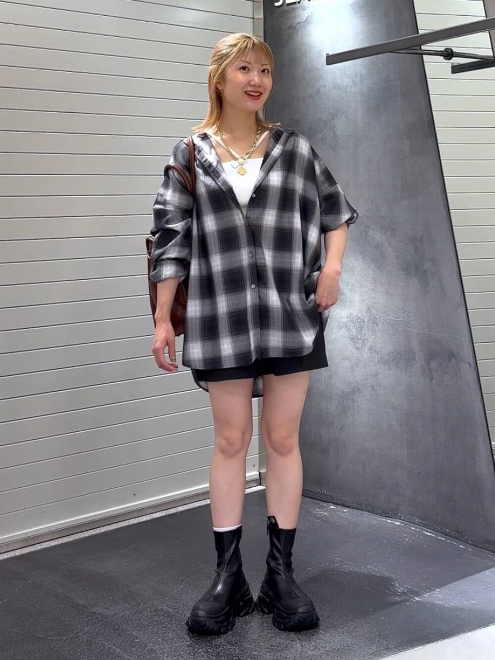 グレー系のシャツ/ブラウス、ブラック系のブーツ、ホワイト系のタンクトップを着用したレディースの秋コーディネートの3枚目の写真