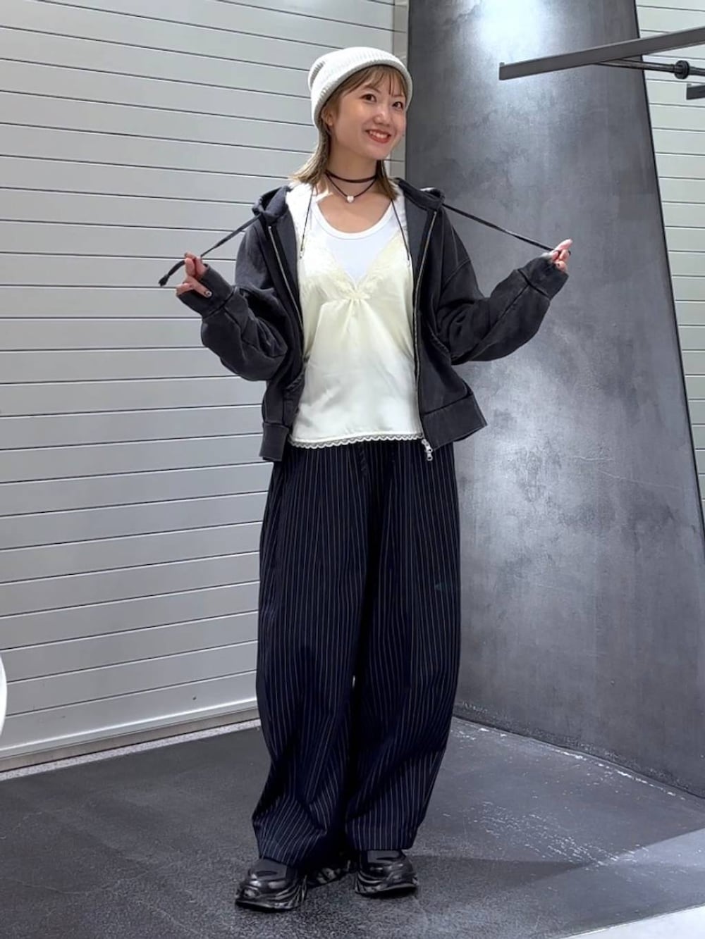 ホワイト系のTシャツ/カットソー、ブラック系のパーカー、ブラック系のスニーカーを着用したレディースの秋コーディネートの2枚目の写真