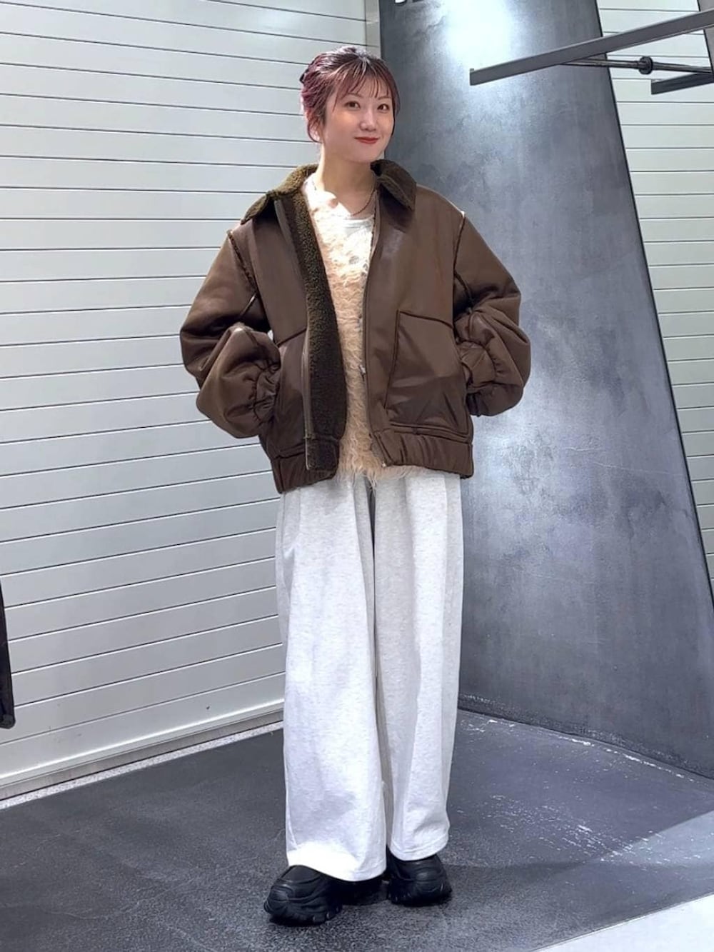 ホワイト系のTシャツ/カットソー、ブラック系のローファー、ブラウン系のブルゾンを着用したレディースの冬コーディネートの2枚目の写真