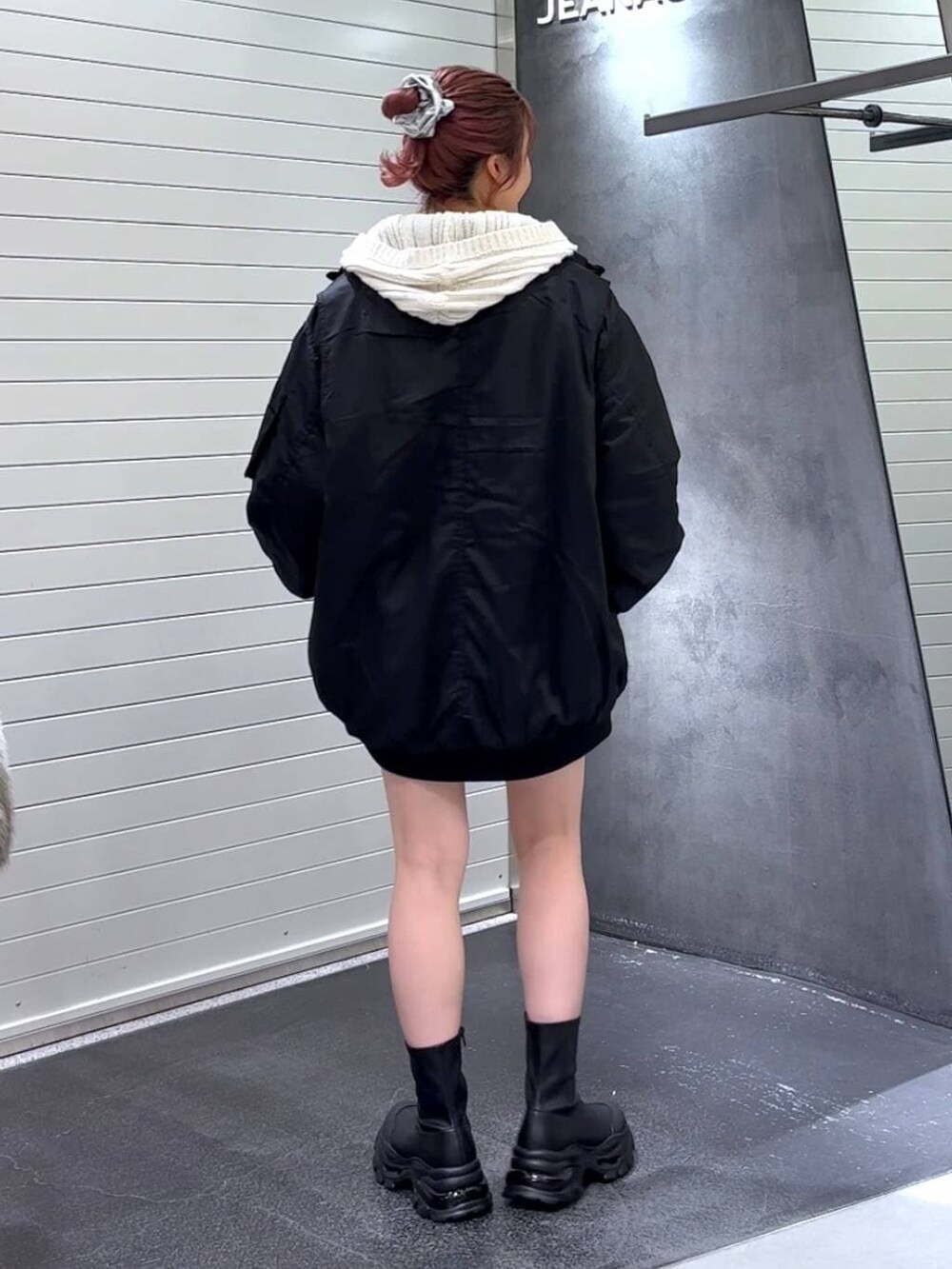 ブラック系のブーツ、ブラック系のブルゾン、ホワイト系のパーカーを着用したレディースの冬コーディネートの5枚目の写真