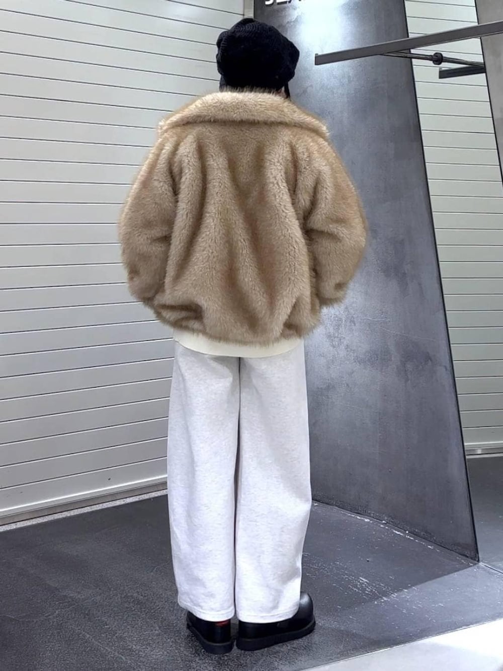 ベージュ系のブルゾン、ブラック系のその他シューズ、ベージュ系のスウェットパンツを着用したレディースの冬コーディネートの5枚目の写真