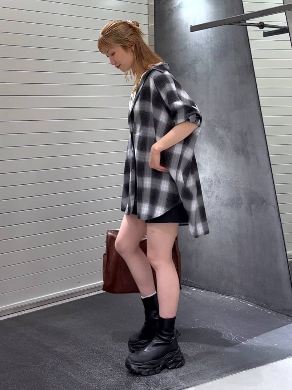 グレー系のシャツ/ブラウス、ブラック系のブーツ、ホワイト系のタンクトップを着用したレディースの秋コーディネートの6枚目の写真