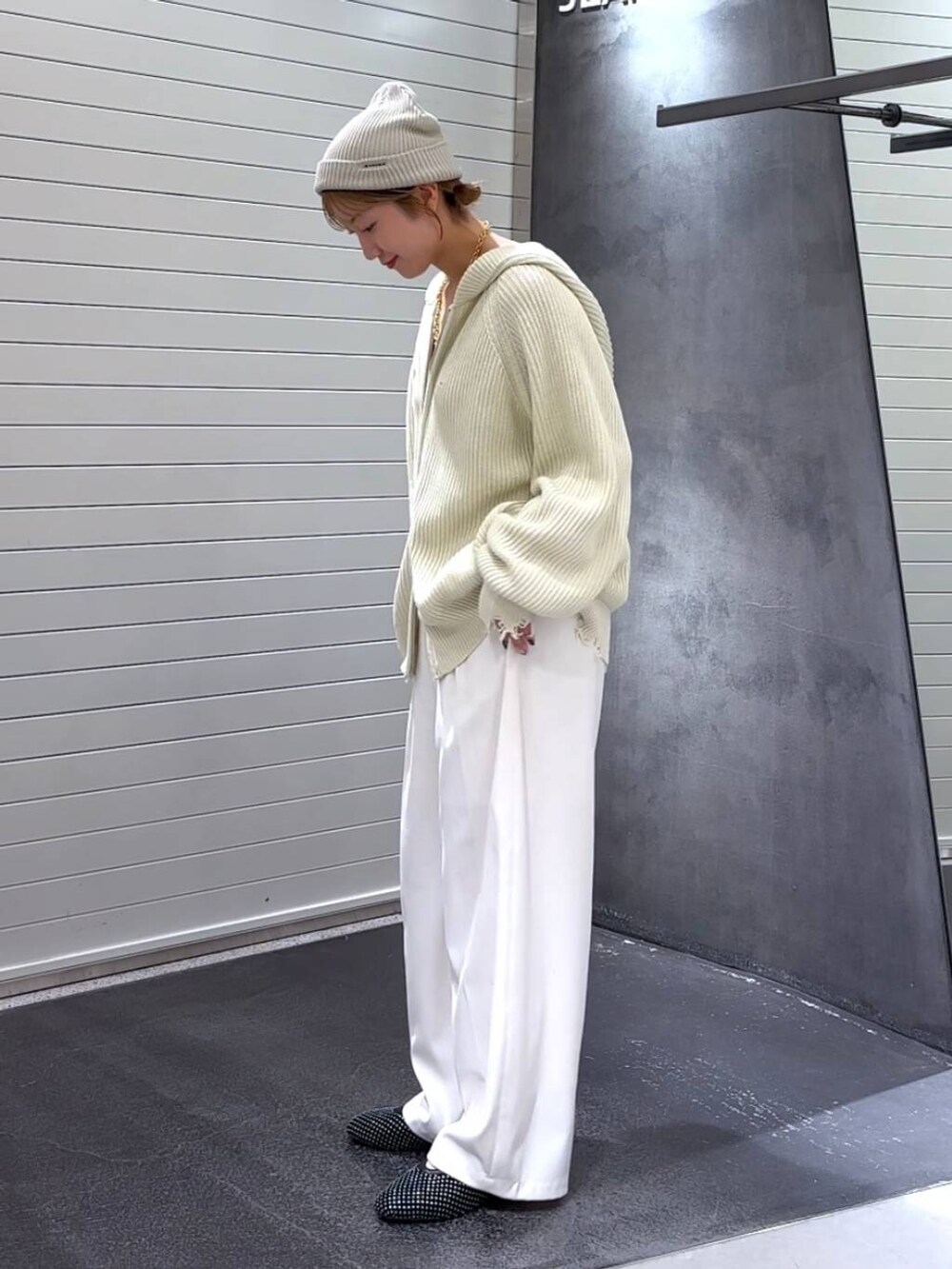 ブラック系のパンプス、ホワイト系のスラックス、ホワイト系のパーカーを着用したレディースの秋コーディネートの6枚目の写真