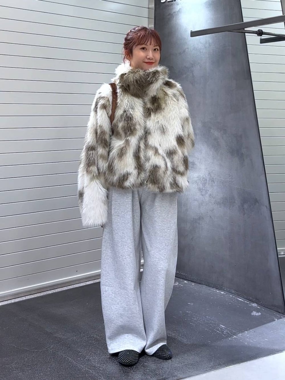 グレー系のブルゾン、ブラウン系のトートバッグ、グレー系のスウェットパンツを着用したレディースの秋コーディネートの3枚目の写真