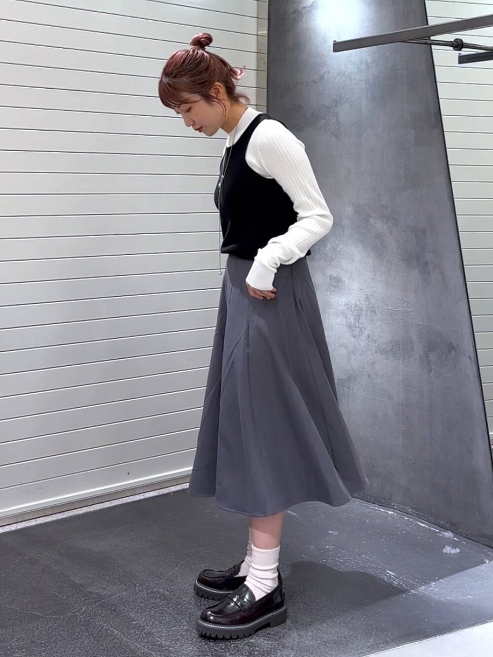 ブラウン系のローファー、ホワイト系のニット/セーター、グレー系のスカートを着用したレディースの秋コーディネートの6枚目の写真