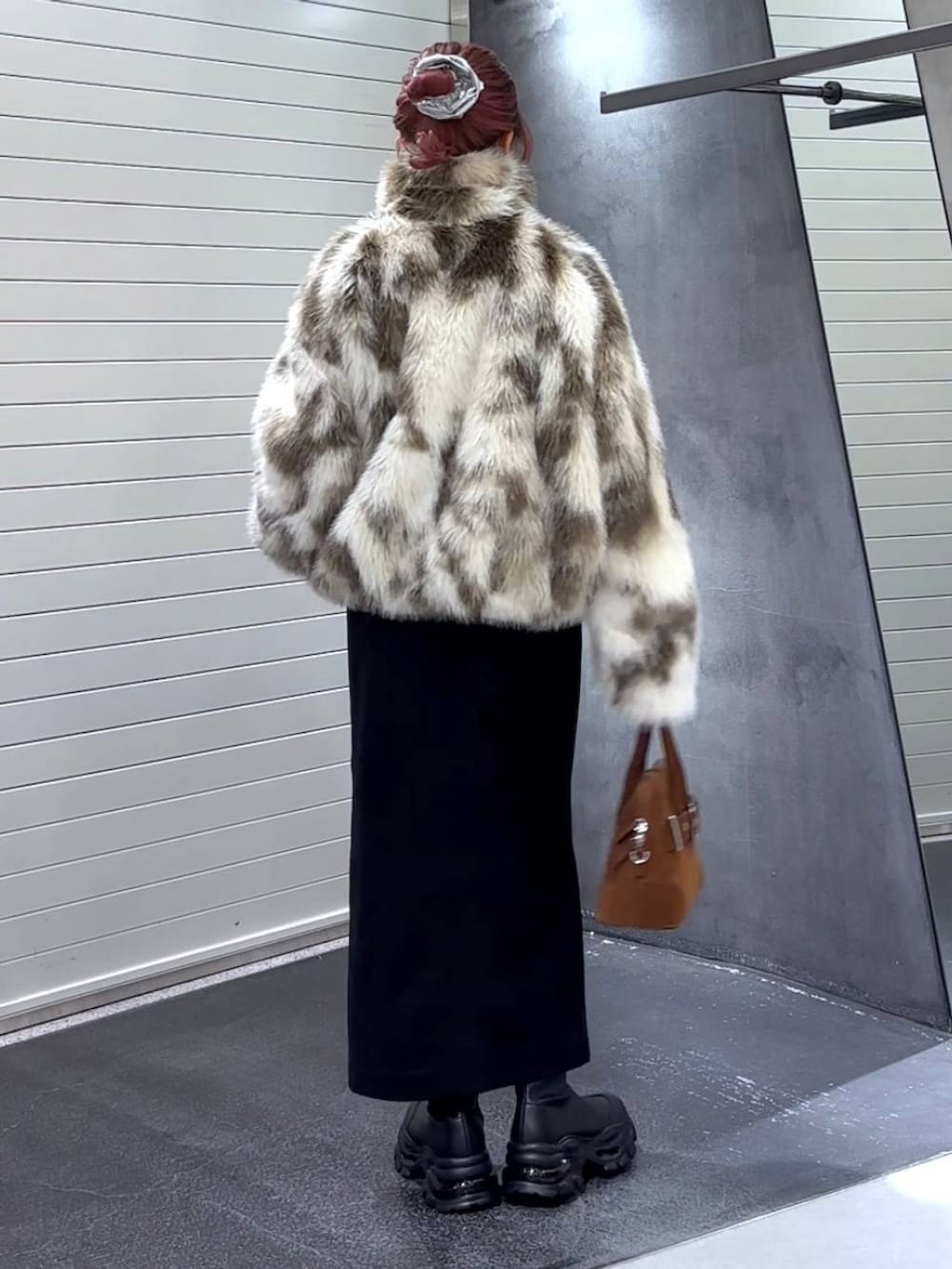 ブラック系のスカート、ホワイト系のブルゾン、ブラック系のブーツを着用したレディースの秋コーディネートの5枚目の写真