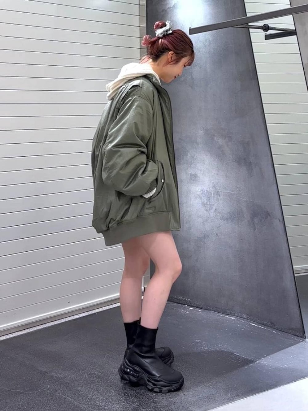 ブラック系のブーツ、グリーン系のブルゾン、ホワイト系のパーカーを着用したレディースの秋コーディネートの5枚目の写真