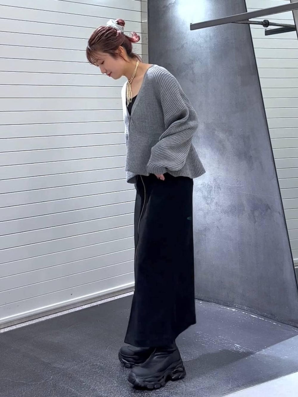 ブラック系のスカート、ブラック系のブーツ、グレー系のカーディガン/ボレロを着用したレディースの秋コーディネートの6枚目の写真