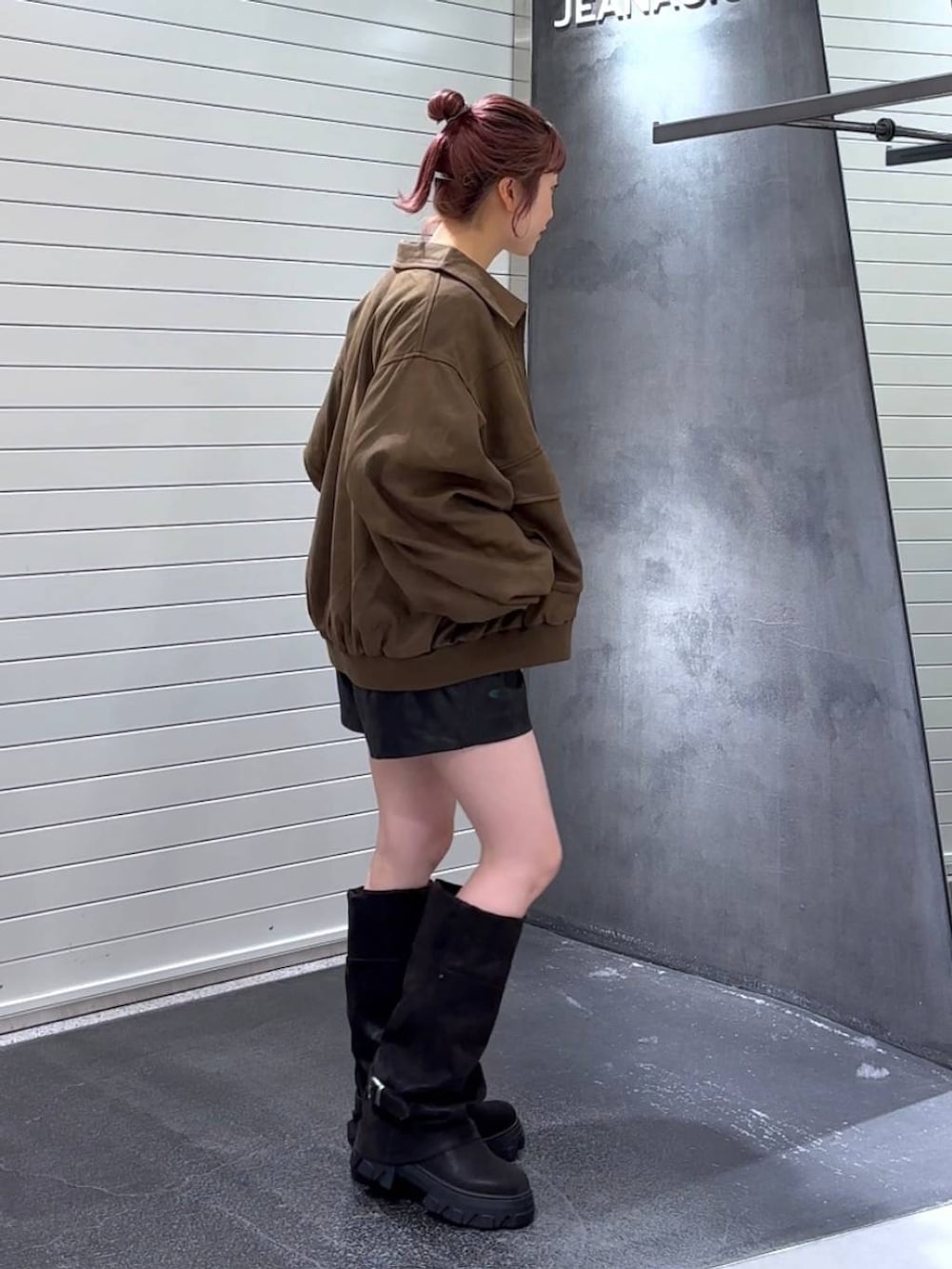 ブラウン系のブルゾン、ブラック系のブーツ、ホワイト系のニット/セーターを着用したレディースの秋コーディネートの4枚目の写真