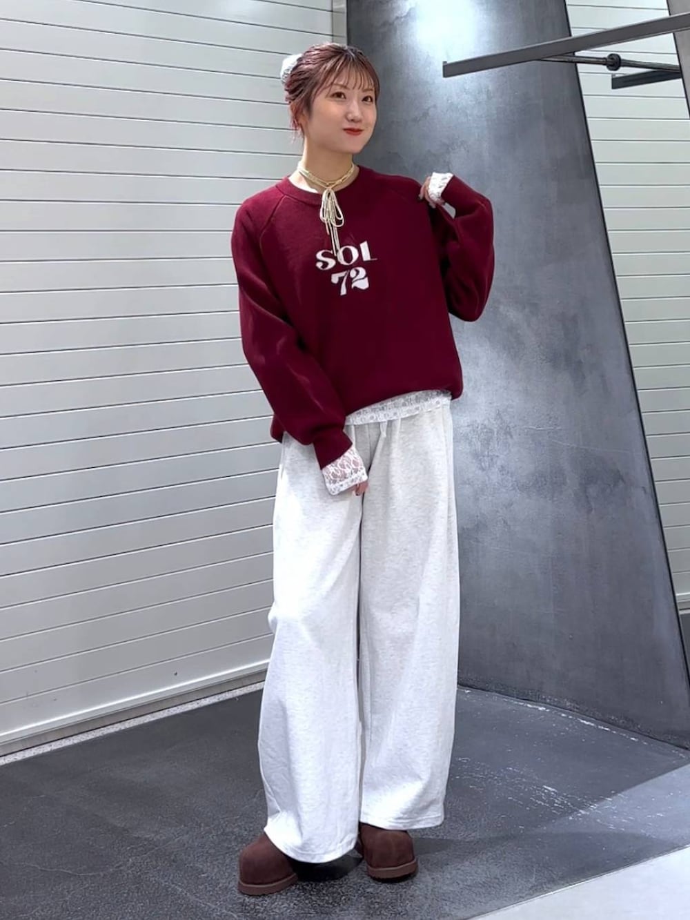 ブラウン系のその他シューズ、レッド系のニット/セーター、ベージュ系のスウェットパンツを着用したレディースの秋コーディネートの3枚目の写真