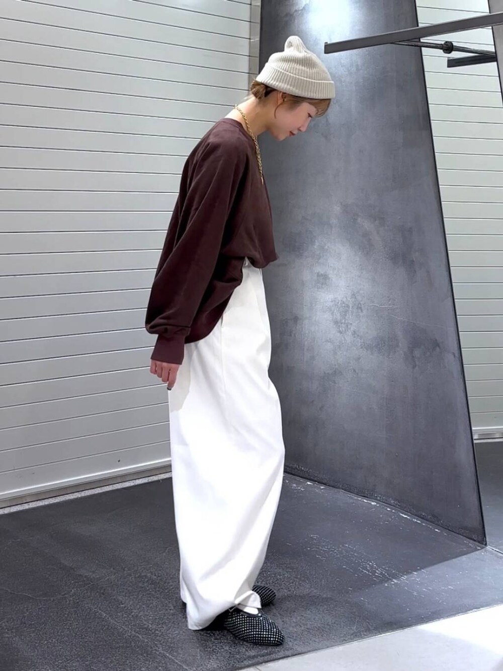 ブラック系のパンプス、ブラウン系のスウェット、ホワイト系のスラックスを着用したレディースの秋コーディネートの4枚目の写真