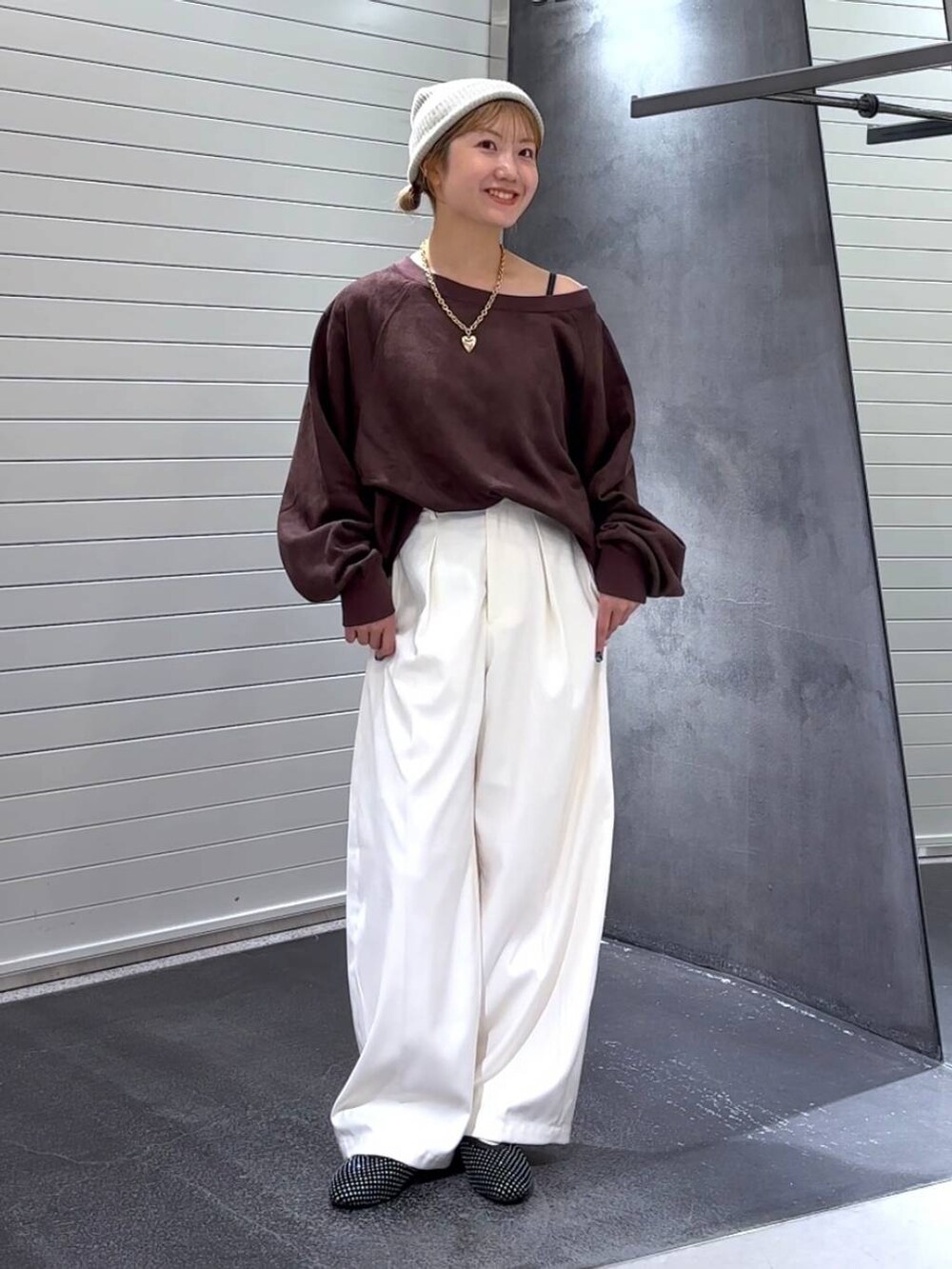 ブラック系のパンプス、ブラウン系のスウェット、ホワイト系のスラックスを着用したレディースの秋コーディネートの3枚目の写真