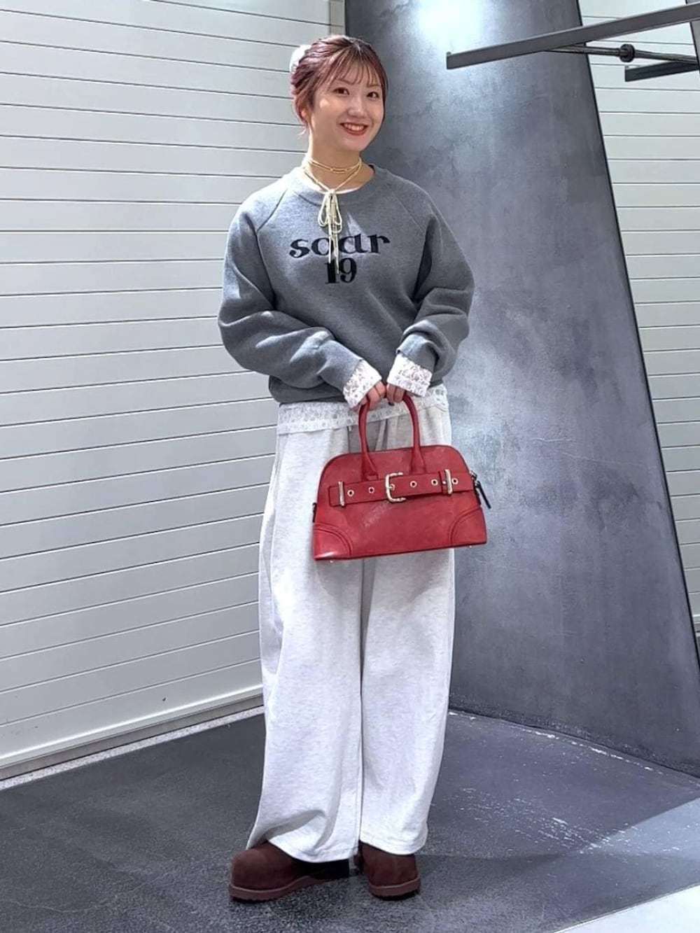 ブラウン系のその他シューズ、レッド系のボストンバッグ、グレー系のニット/セーターを着用したレディースの秋コーディネートの2枚目の写真