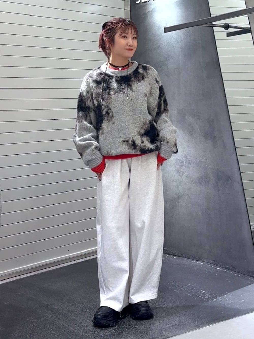 グレー系のニット/セーター、ブラック系のローファー、ベージュ系のスウェットパンツを着用したレディースの秋コーディネートの2枚目の写真