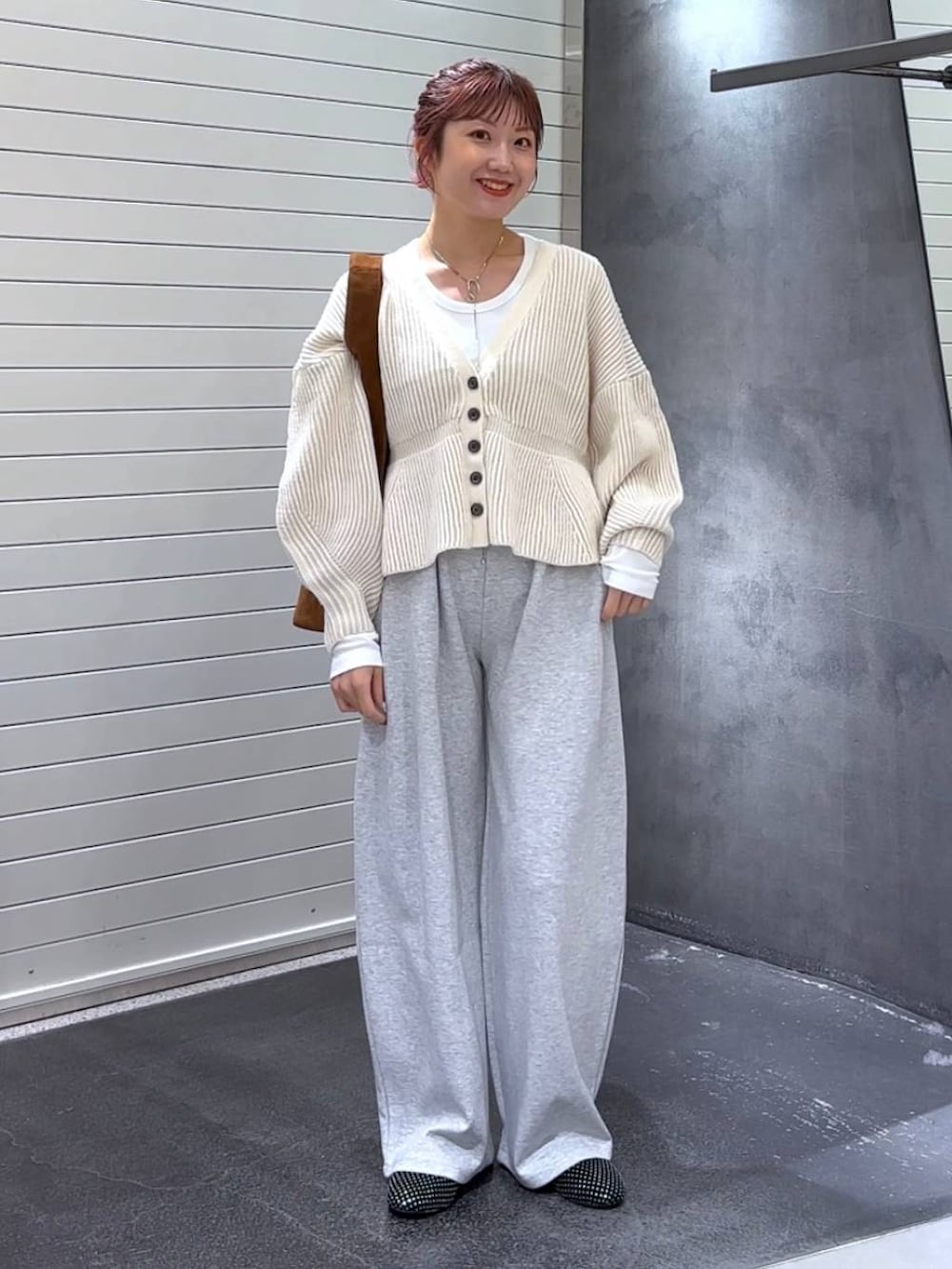 ホワイト系のTシャツ/カットソー、グレー系のスウェットパンツ、ブラウン系のトートバッグを着用したレディースの秋コーディネートの2枚目の写真