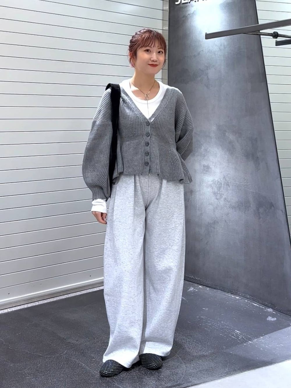 ホワイト系のTシャツ/カットソー、グレー系のスウェットパンツ、ブラック系のトートバッグを着用したレディースの秋コーディネートの2枚目の写真