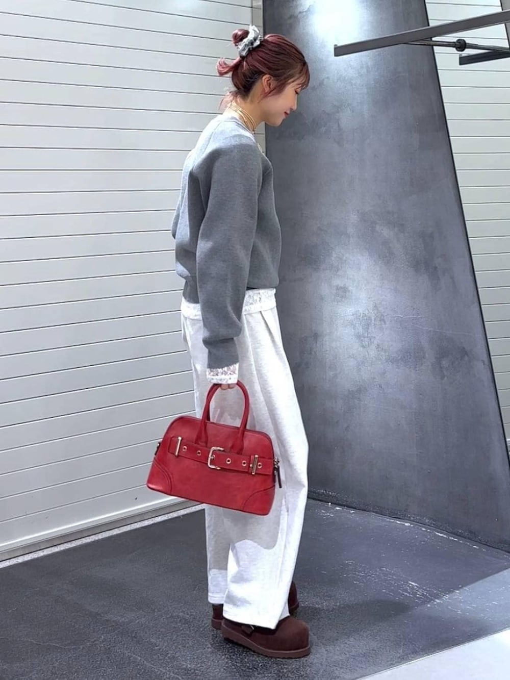 ブラウン系のその他シューズ、レッド系のボストンバッグ、グレー系のニット/セーターを着用したレディースの秋コーディネートの4枚目の写真