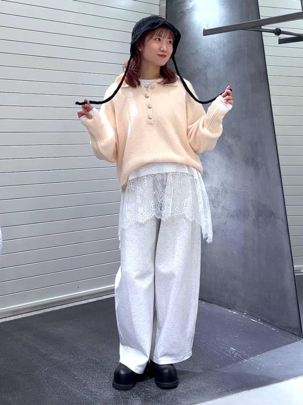 ブラック系のその他シューズ、ホワイト系のTシャツ/カットソー、ベージュ系のスウェットパンツを着用したレディースの冬コーディネートの3枚目の写真