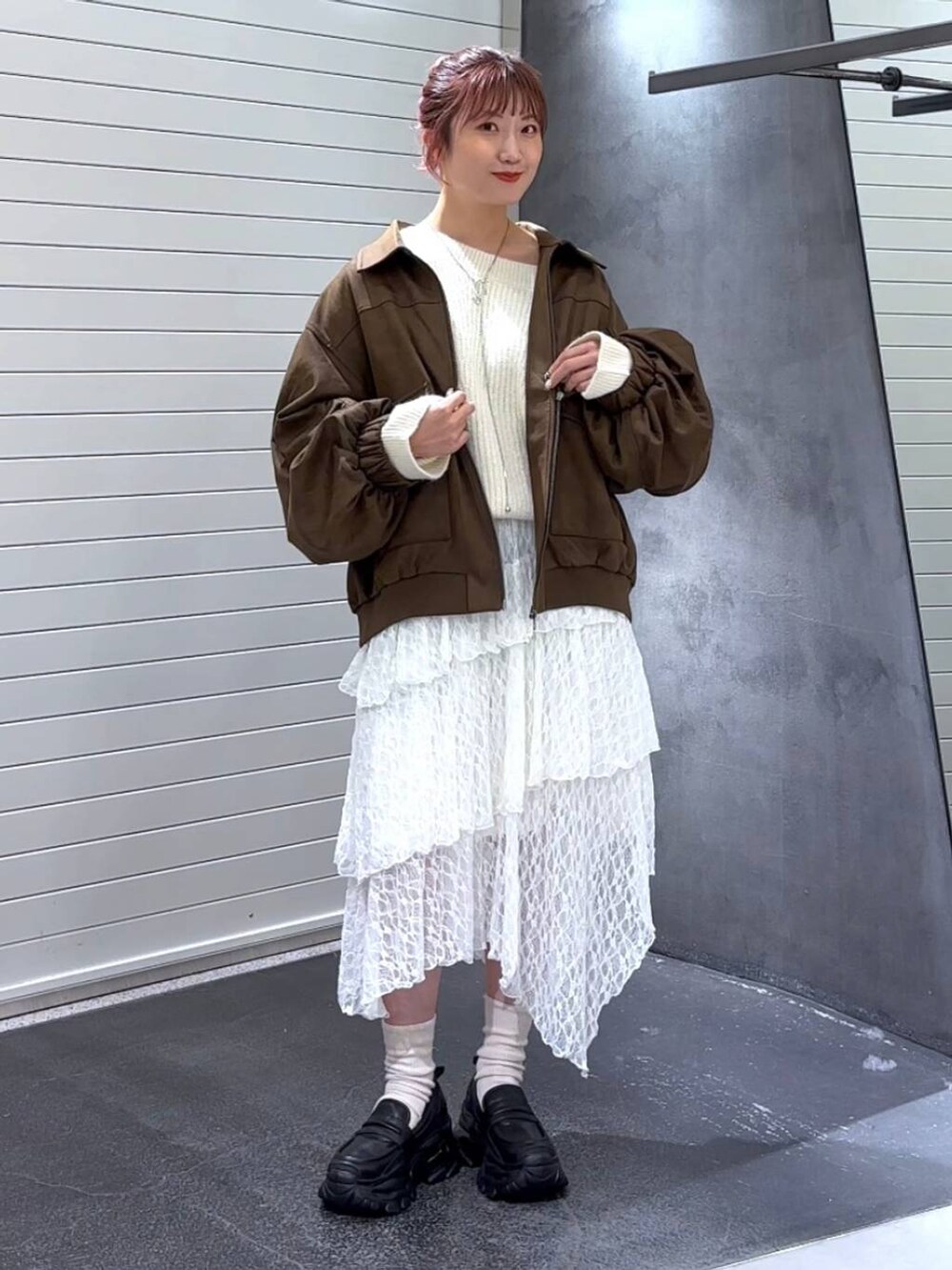 ブラック系のローファー、ホワイト系のスカート、ホワイト系のニット/セーターを着用したレディースの秋コーディネートの2枚目の写真