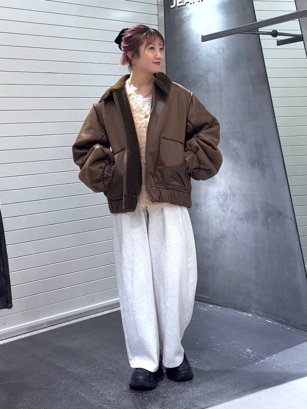 ホワイト系のTシャツ/カットソー、ブラック系のローファー、ブラウン系のブルゾンを着用したレディースの冬コーディネートの3枚目の写真
