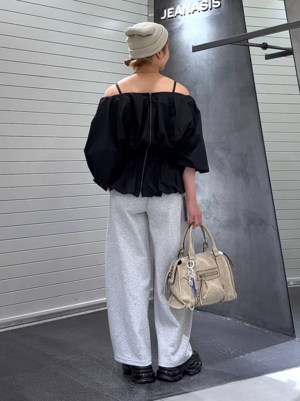 ベージュ系のボストンバッグ、ブラック系のローファー、グレー系のスウェットパンツを着用したレディースの秋コーディネートの5枚目の写真