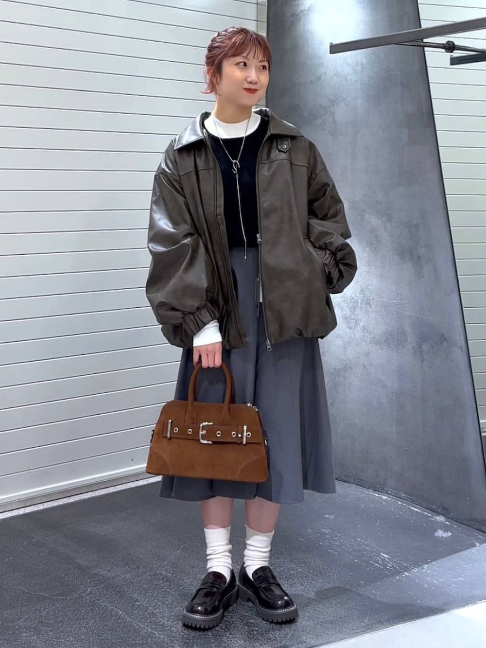 ブラウン系のブルゾン、ブラウン系のローファー、ブラウン系のボストンバッグを着用したレディースの秋コーディネートの3枚目の写真