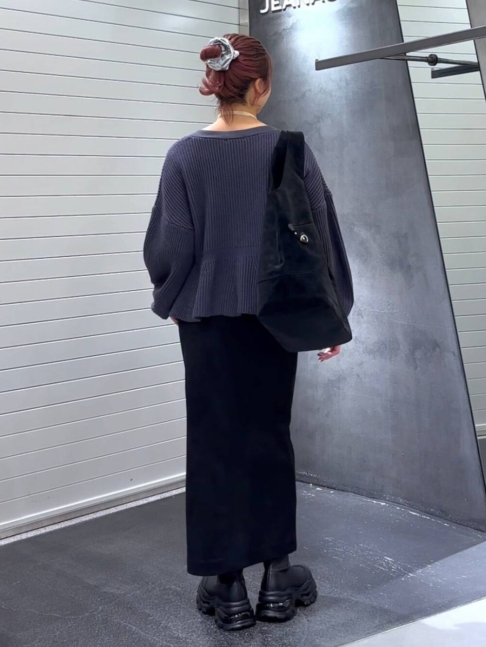 ブラック系のスカート、ブラック系のブーツ、ブラック系のトートバッグを着用したレディースの秋コーディネートの5枚目の写真