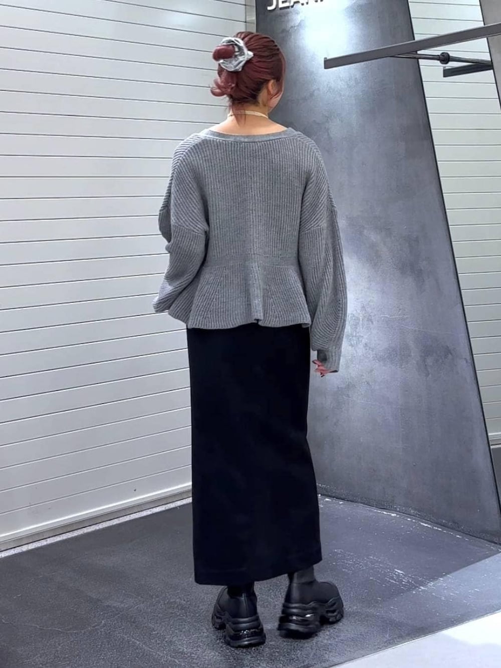 ブラック系のスカート、ブラック系のブーツ、グレー系のカーディガン/ボレロを着用したレディースの秋コーディネートの5枚目の写真
