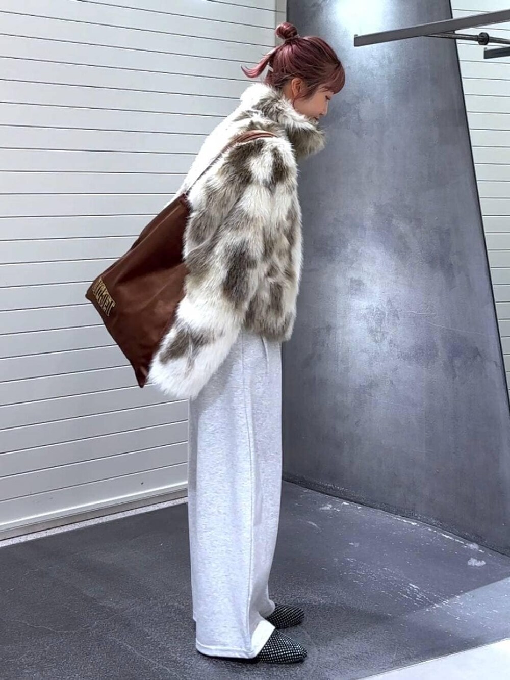 ホワイト系のブルゾン、ブラウン系のトートバッグ、グレー系のスウェットパンツを着用したレディースの冬コーディネートの4枚目の写真