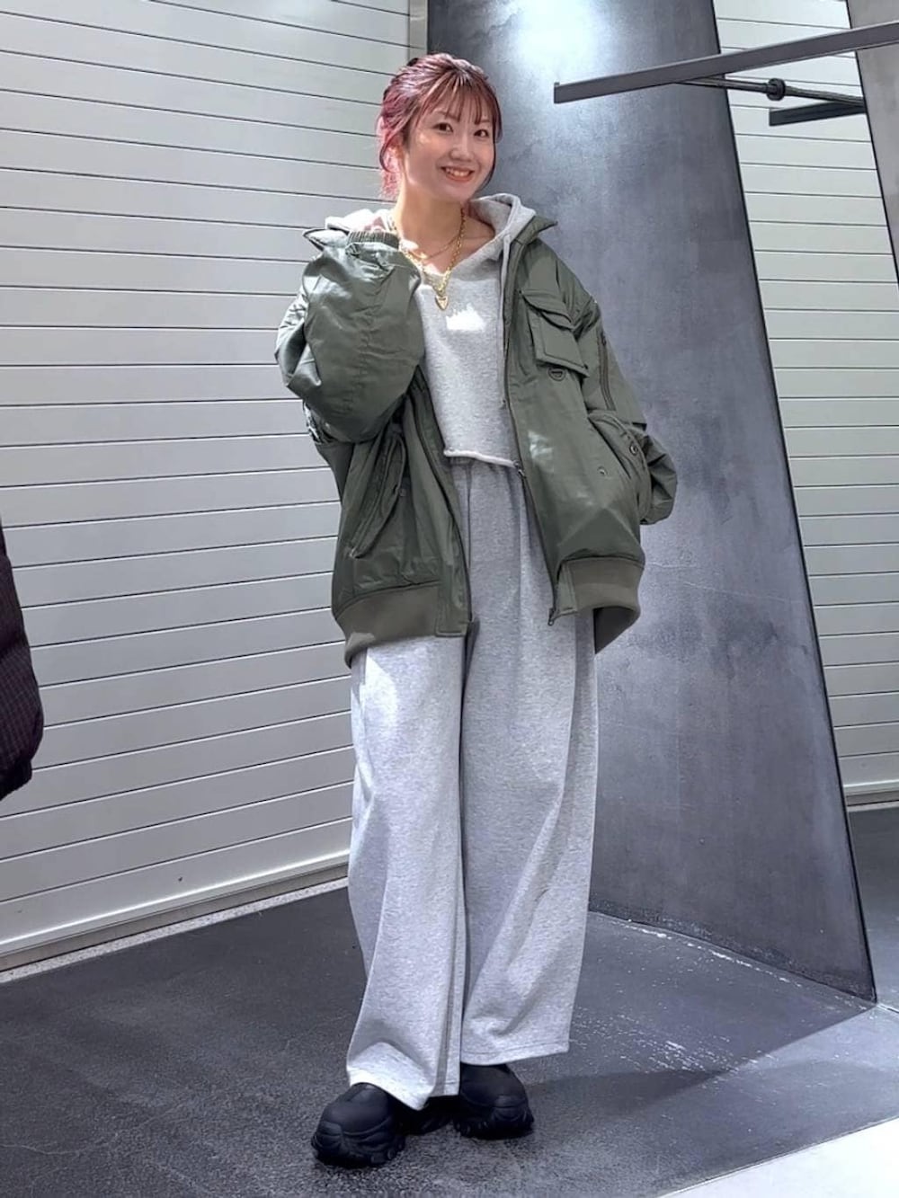 ブラック系のブーツ、グリーン系のブルゾン、グレー系のパーカーを着用したレディースの冬コーディネートの3枚目の写真