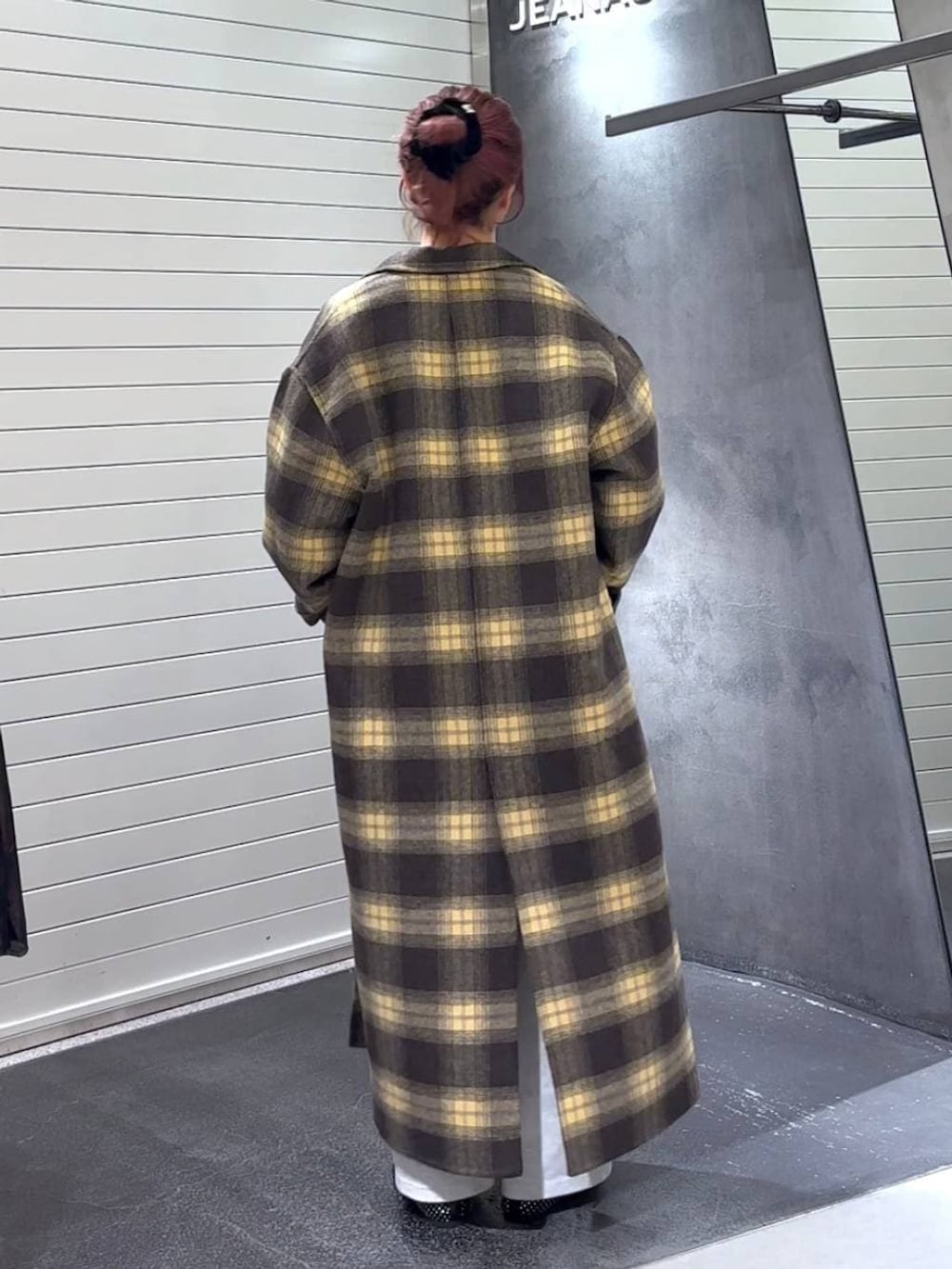 ブラウン系のチェスターコート、ブラック系のパンプス、グレー系のTシャツ/カットソーを着用したレディースの冬コーディネートの5枚目の写真