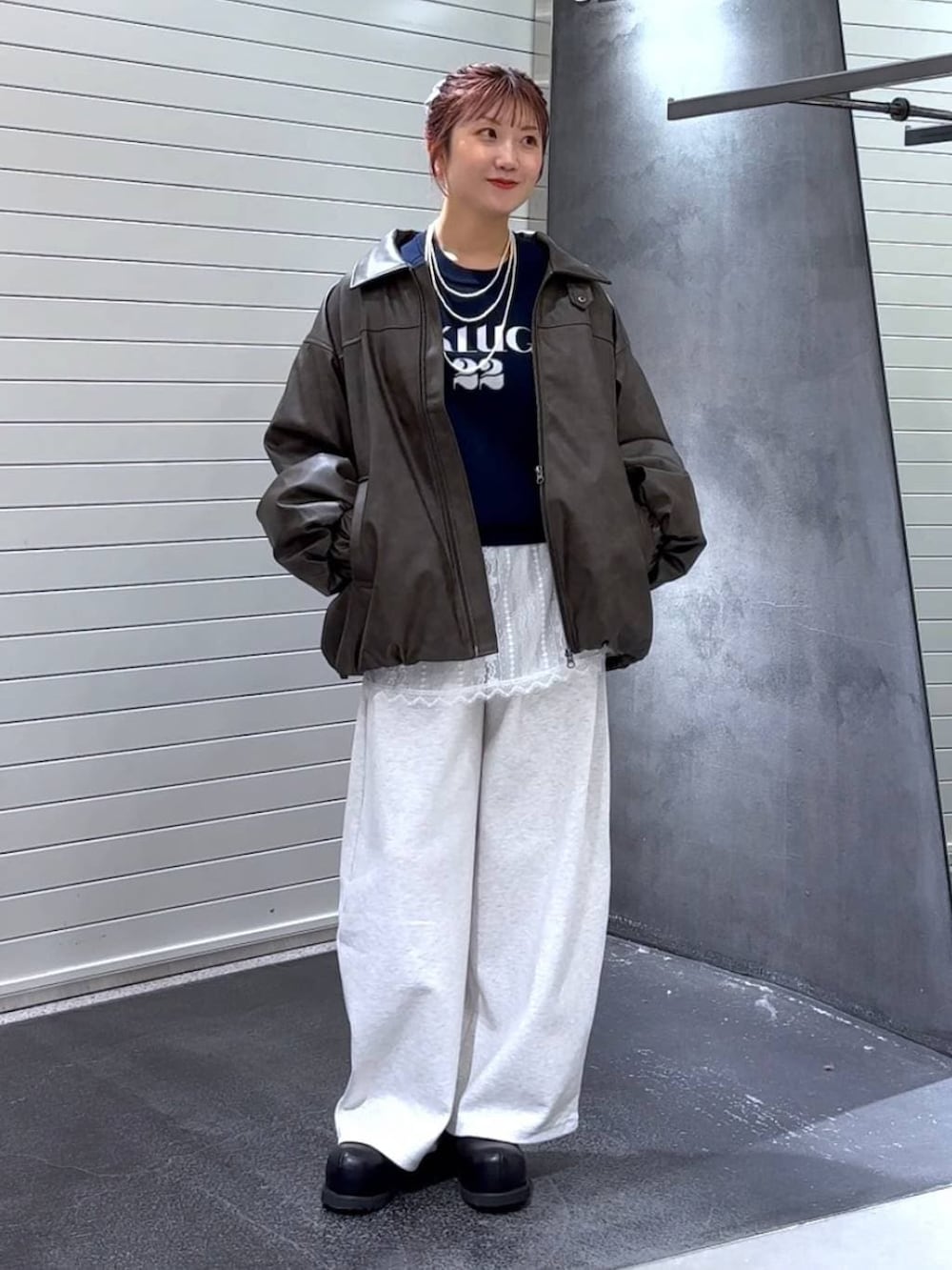 ブラウン系のブルゾン、ホワイト系のその他トップス、ブラック系のその他シューズを着用したレディースの冬コーディネートの2枚目の写真