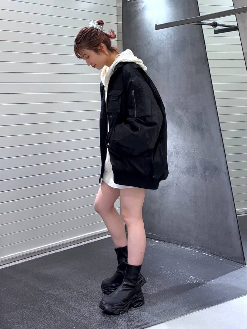 ブラック系のブーツ、ブラック系のブルゾン、ホワイト系のパーカーを着用したレディースの冬コーディネートの6枚目の写真