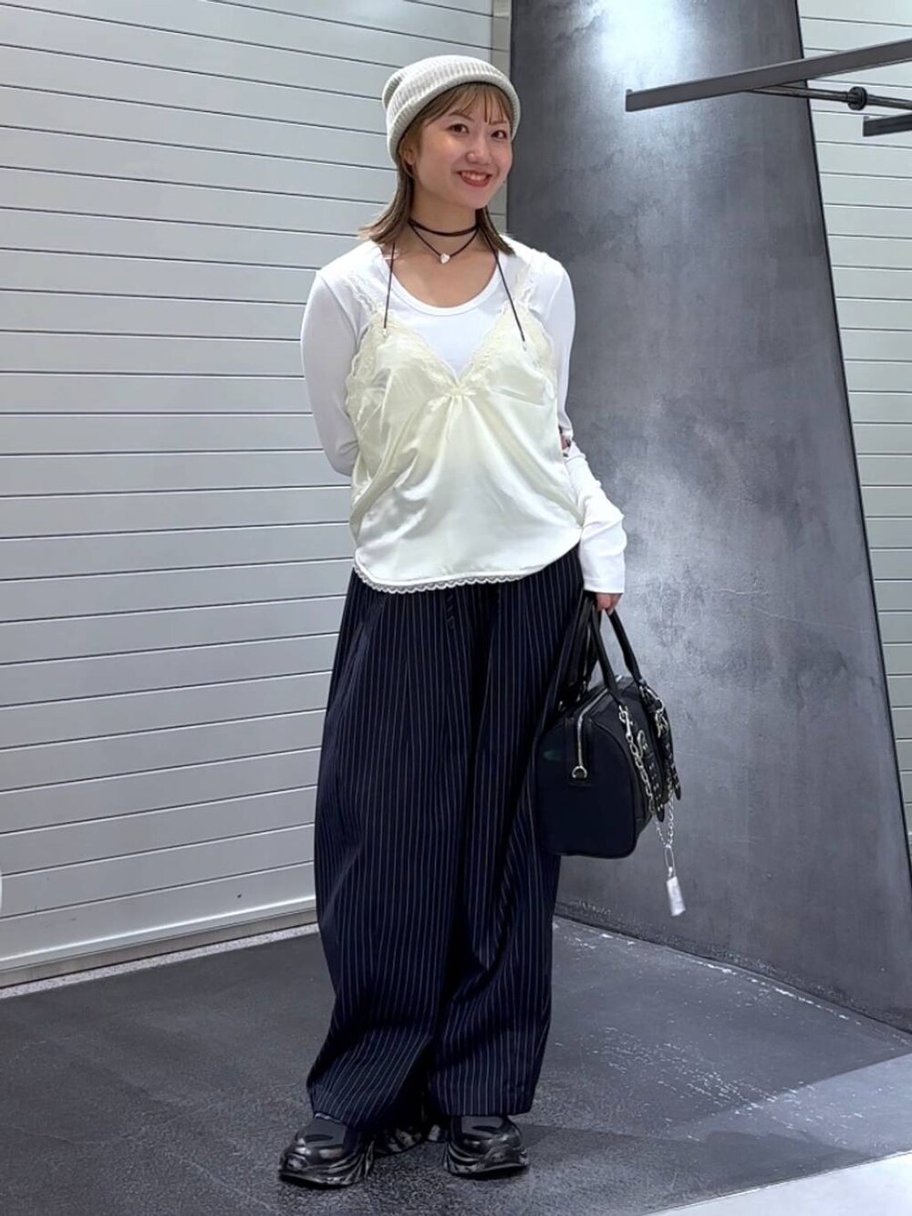 ホワイト系のTシャツ/カットソー、ブラック系のスニーカー、ブルー系のスラックスを着用したレディースの秋コーディネートの2枚目の写真