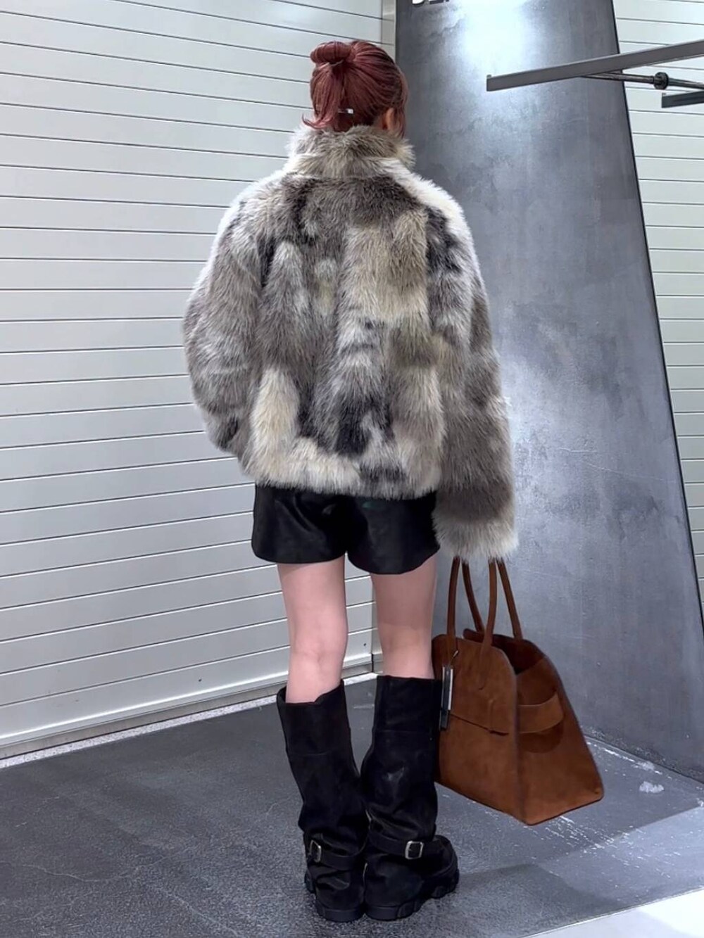 グレー系のブルゾン、ブラック系のブーツ、ブラウン系のショルダーバッグを着用したレディースの秋コーディネートの5枚目の写真