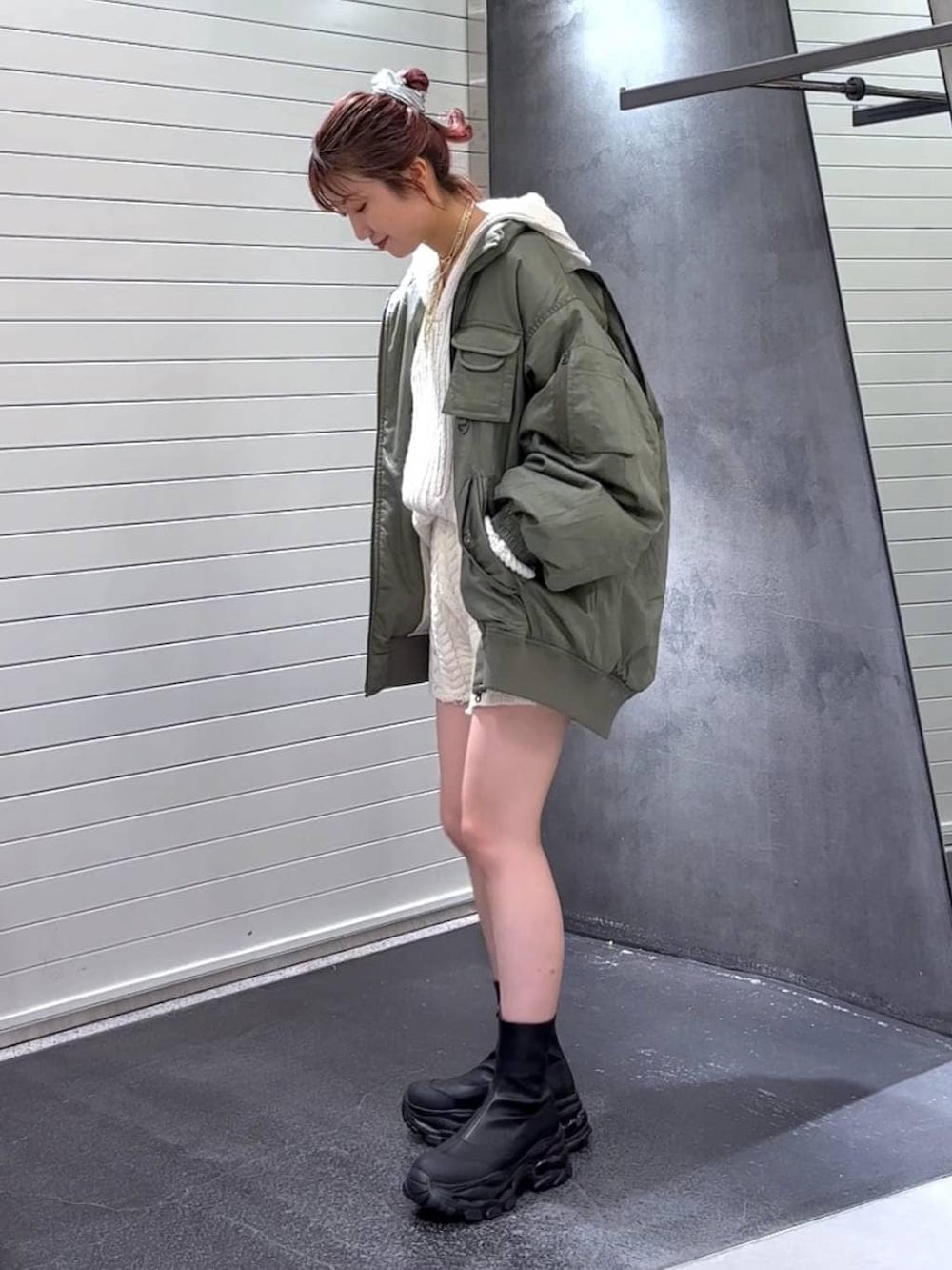 ブラック系のブーツ、グリーン系のブルゾン、ホワイト系のパーカーを着用したレディースの秋コーディネートの7枚目の写真