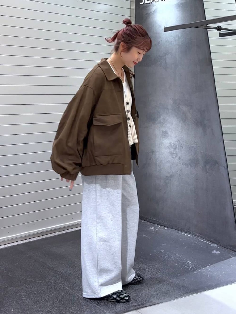 ホワイト系のTシャツ/カットソー、グレー系のスウェットパンツ、ブラック系のパンプスを着用したレディースの秋コーディネートの4枚目の写真