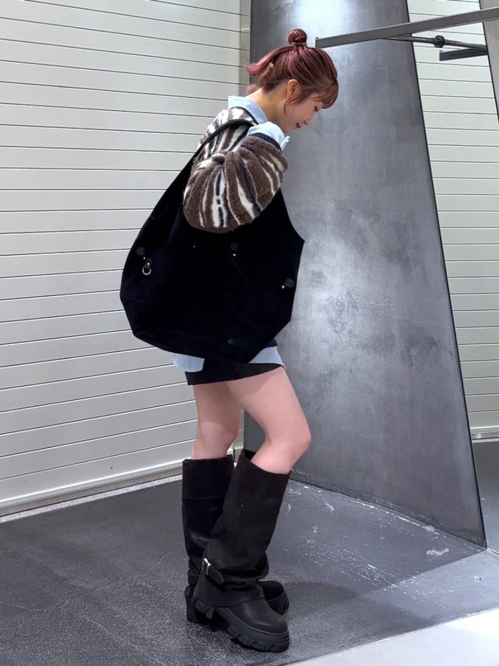 ブラック系のブーツ、ブルー系のシャツ/ブラウス、ブラック系のトートバッグを着用したレディースの秋コーディネートの4枚目の写真