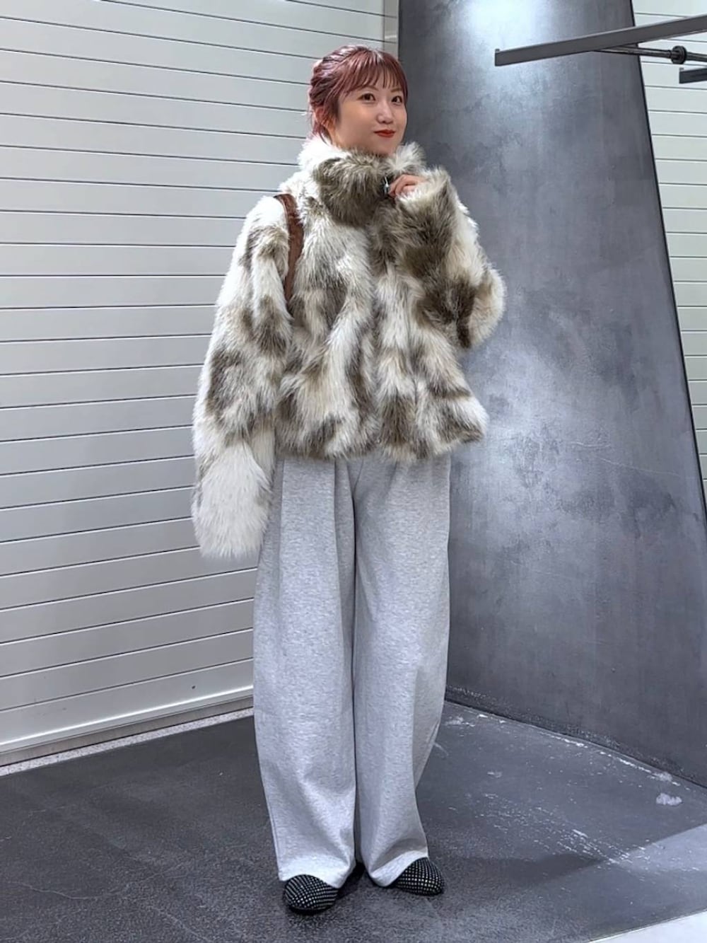 グレー系のブルゾン、ブラウン系のトートバッグ、グレー系のスウェットパンツを着用したレディースの秋コーディネートの2枚目の写真