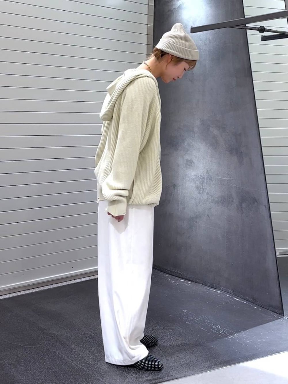 ブラック系のパンプス、ホワイト系のスラックス、ホワイト系のパーカーを着用したレディースの秋コーディネートの4枚目の写真