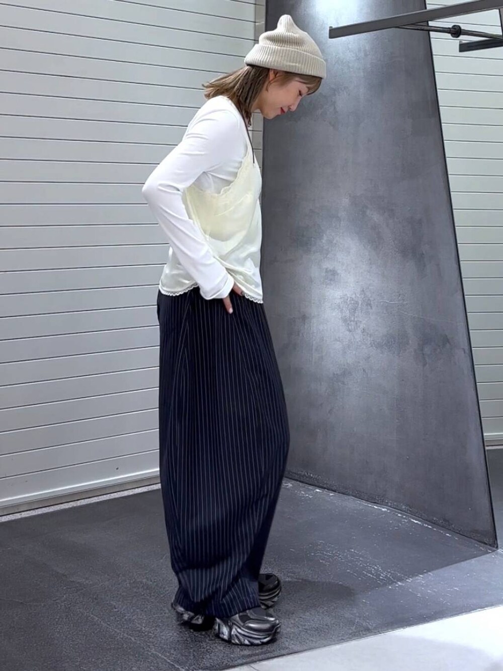 ホワイト系のTシャツ/カットソー、ブラック系のスニーカー、ブルー系のスラックスを着用したレディースの秋コーディネートの4枚目の写真