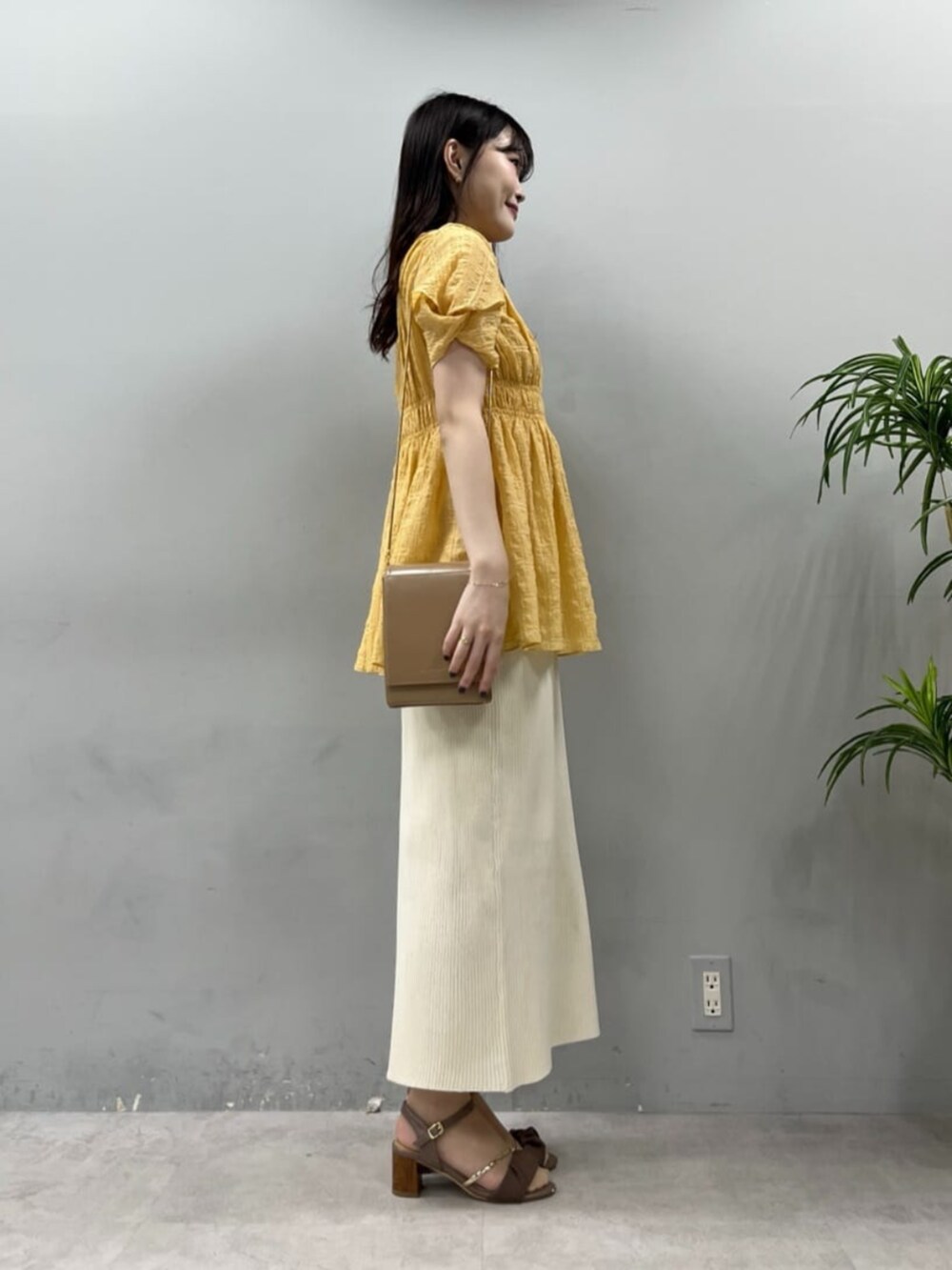 ブラウン系のその他シューズ、ベージュ系のショルダーバッグ、ホワイト系のスカートを着用したレディースの夏コーディネートの5枚目の写真