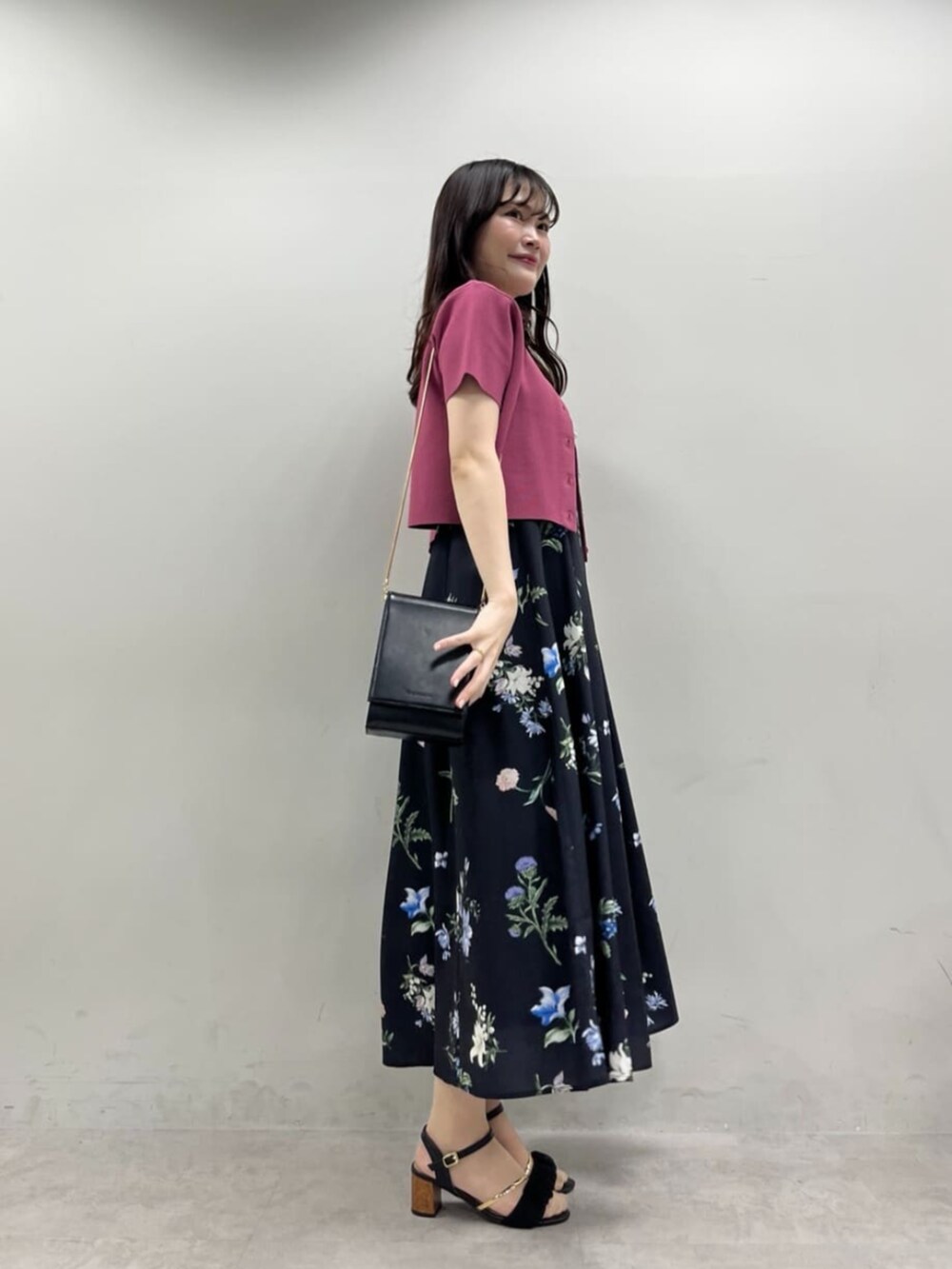 ブラック系のショルダーバッグ、ブラック系のワンピース、ピンク系のカーディガン/ボレロを着用したレディースの夏コーディネートの4枚目の写真