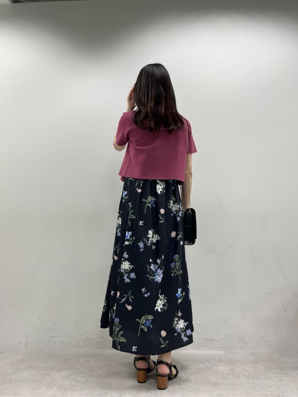 ブラック系のショルダーバッグ、ブラック系のワンピース、ピンク系のカーディガン/ボレロを着用したレディースの夏コーディネートの3枚目の写真